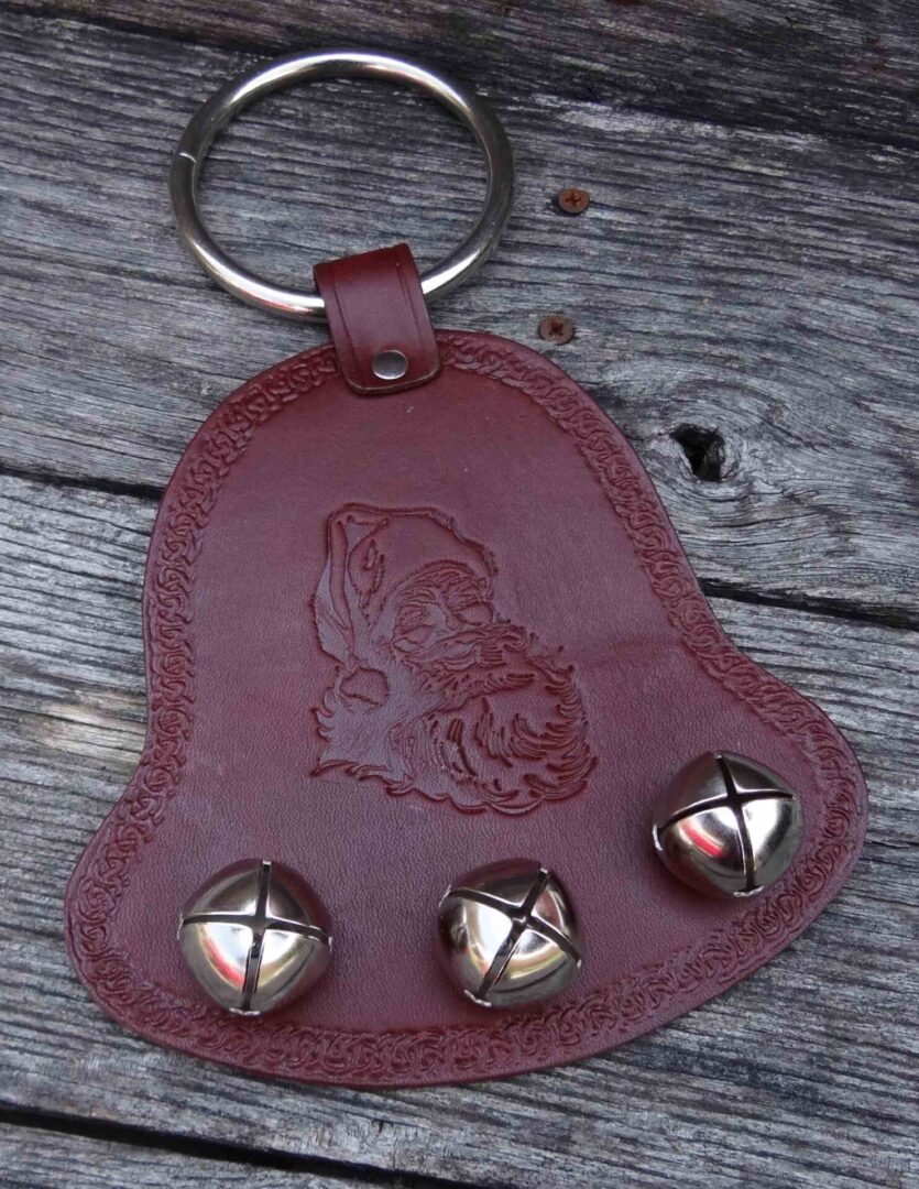 A leather key chain with bells on it.