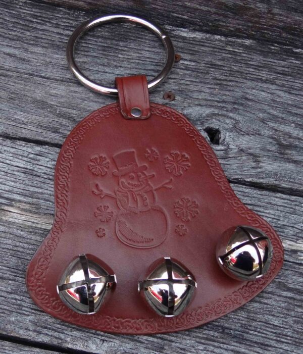 A brown leather key chain with three bells on it.