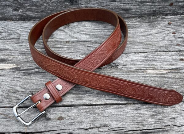 A brown leather belt sitting on top of a wooden table.