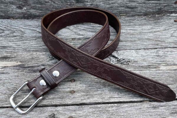 A brown leather belt sitting on top of a wooden table.