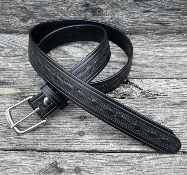 A black belt laying on top of a wooden table.