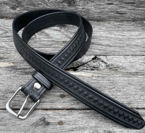 A black leather belt laying on top of a wooden table.