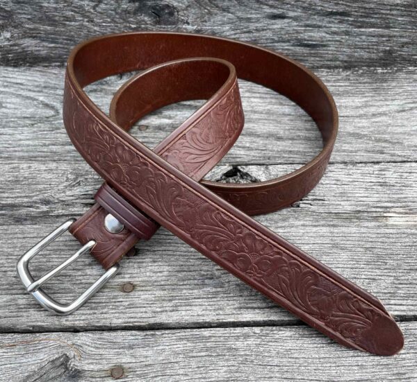 A brown leather belt sitting on top of a wooden table.