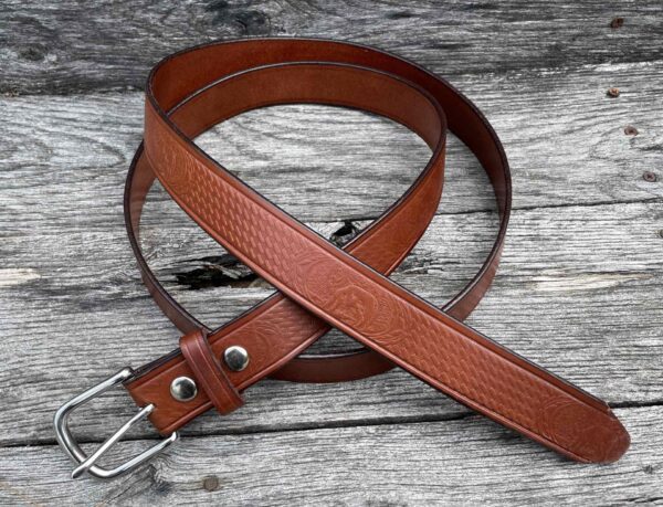 A brown leather belt sitting on top of a wooden table.