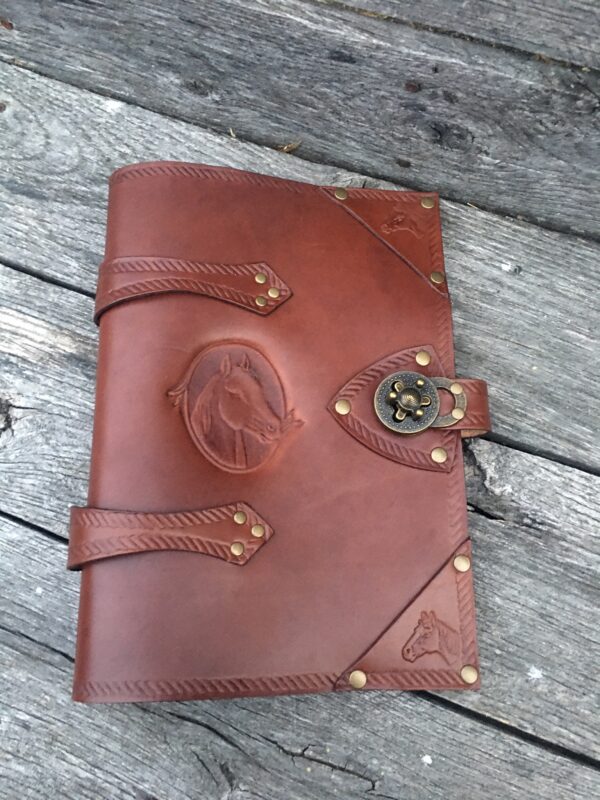 A brown leather book with a horse on the cover.