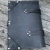 A black leather book with metal rivets on the cover.