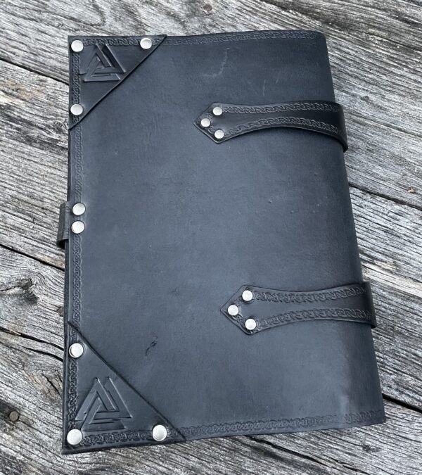 A black leather book with metal rivets on the cover.