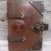 A leather book with a tree of life on the front cover.
