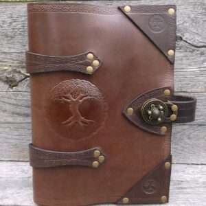 A leather book with a tree of life on the front cover.