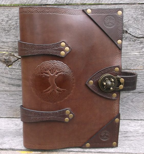 A leather book with a tree of life on the front cover.