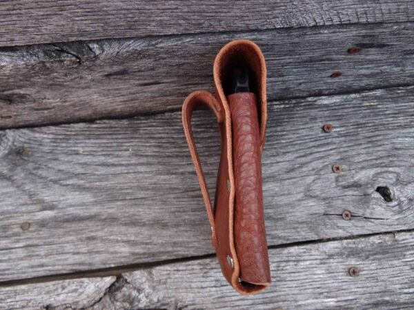 A brown leather case is sitting on the ground.