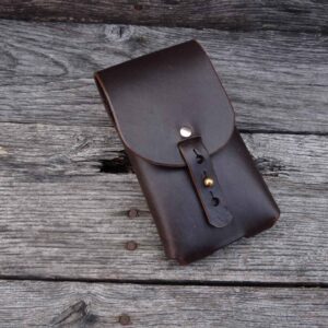 A brown leather case sitting on top of a wooden table.