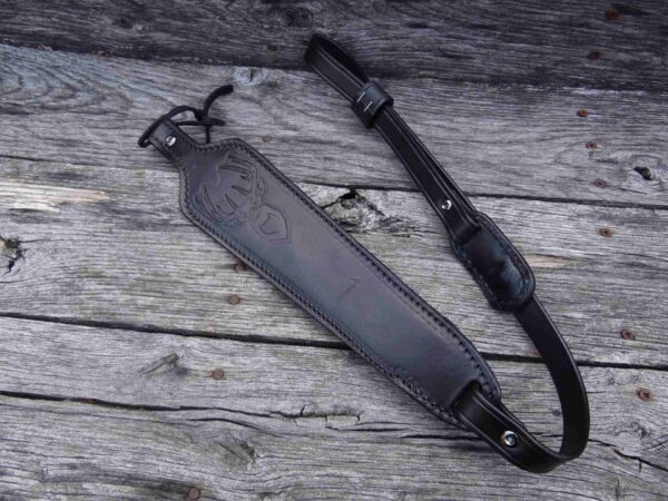 A black leather strap laying on top of a wooden table.