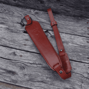 A red strap laying on top of a wooden table.