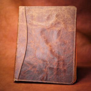 A brown leather book sitting on top of a table.