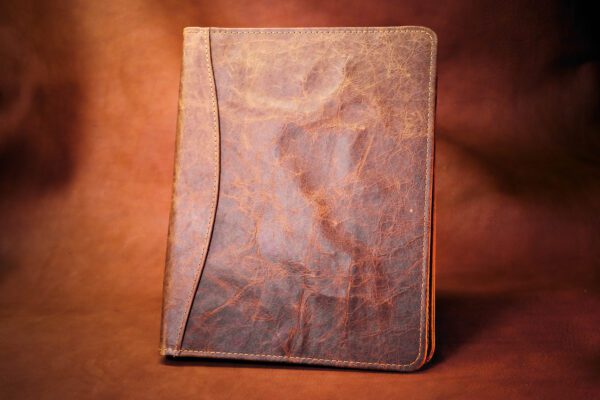 A brown leather book sitting on top of a table.