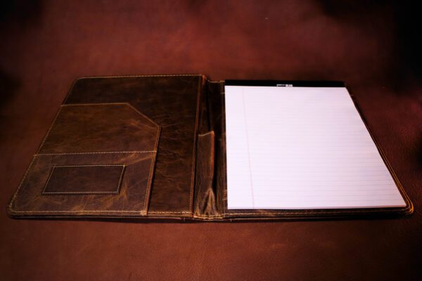 A brown leather folder with papers inside of it.