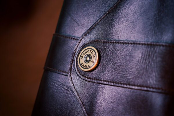 A close up of the button on a leather bag.