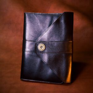 A black leather book with a button on the front.