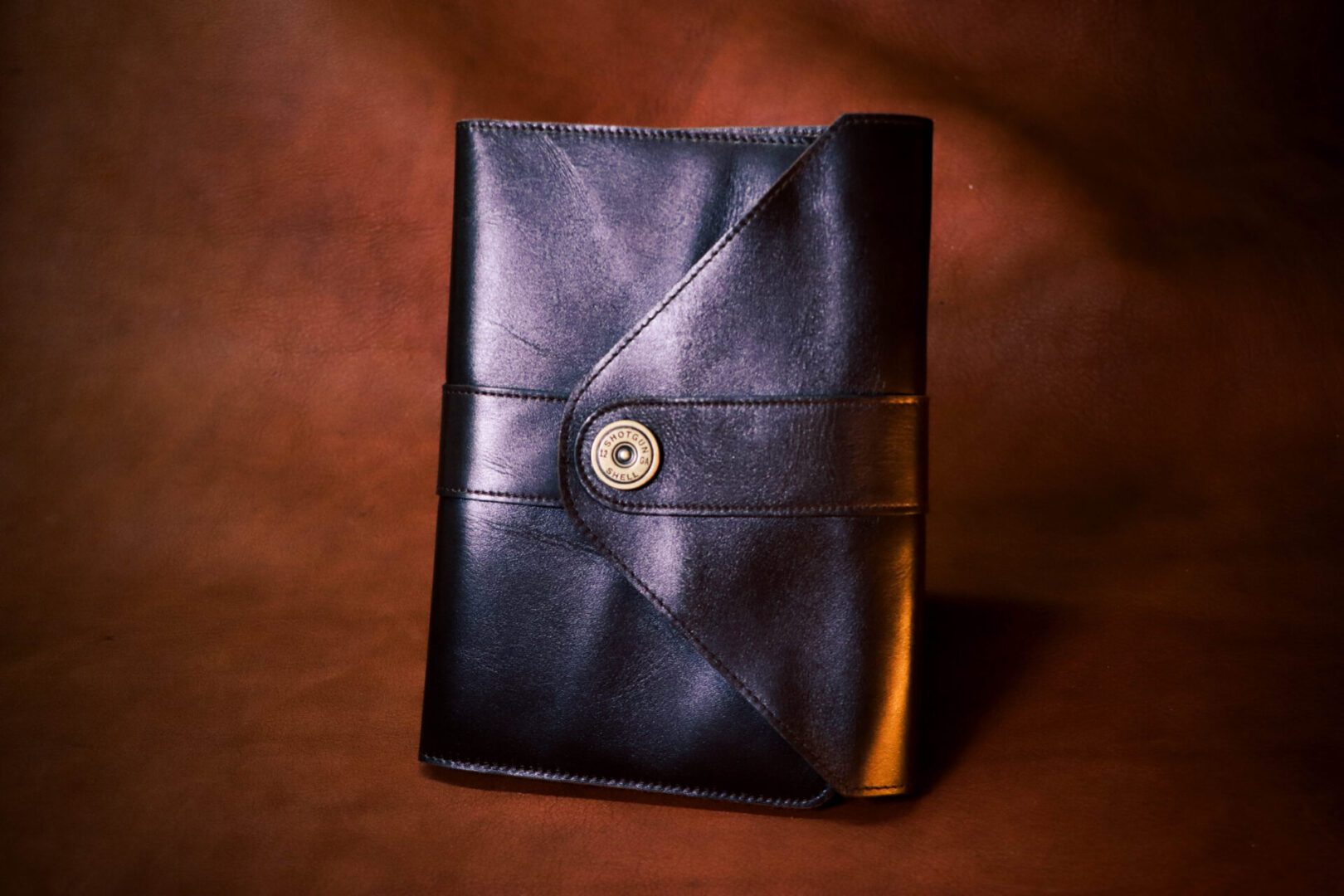 A black leather book with a button on the front.