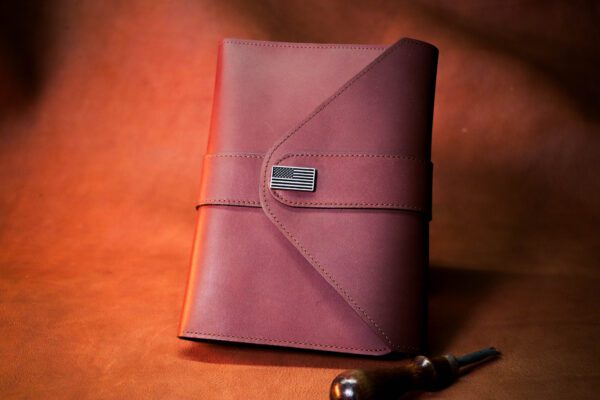 A red leather notebook sitting on top of a table.