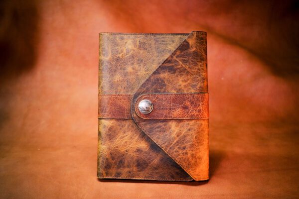 A leather book with a button on the front cover.