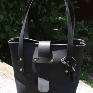 A black purse sitting on top of a stone slab.