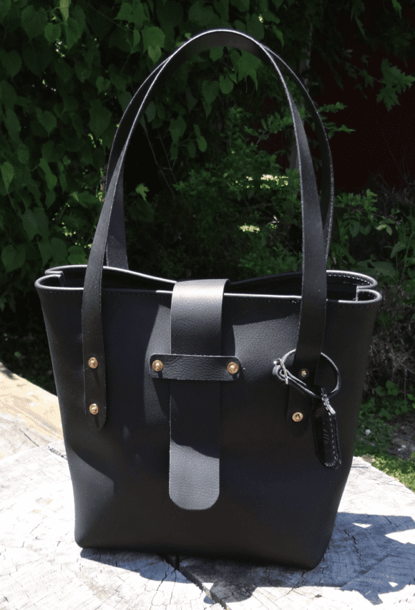 A black purse sitting on top of a stone slab.