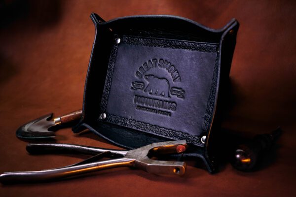 A pair of scissors and a tray on top of a table.