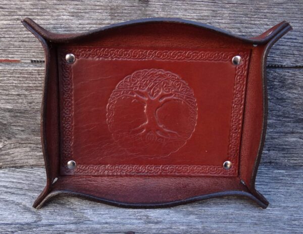 A red leather tray with a tree of life design.