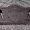 A leather belt with an image of a deer on it.
