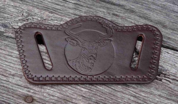 A leather belt with an image of a deer on it.