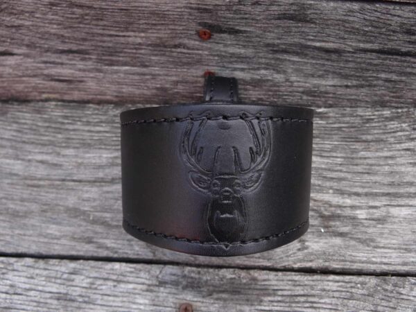 A black leather bracelet with a picture of a crown on it.