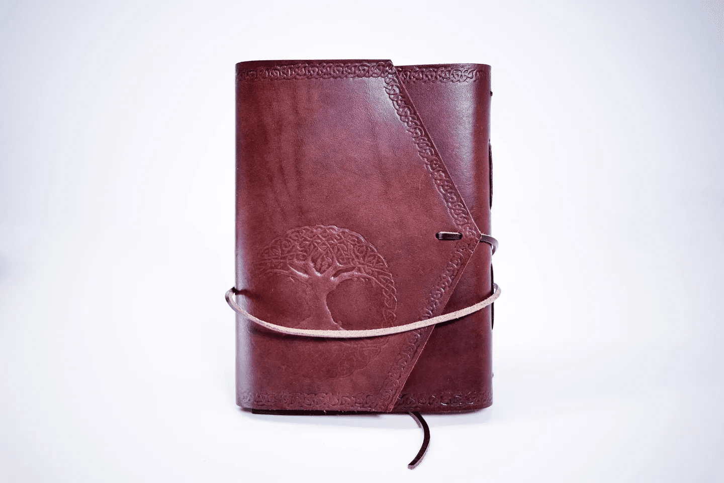 A brown leather book with a tree on the cover.