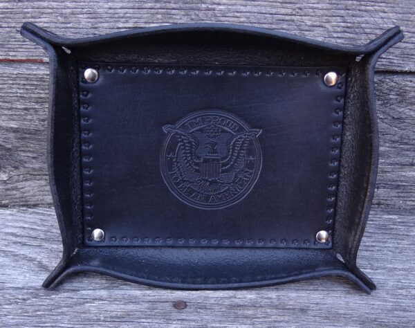 A black leather tray with a seal on it.