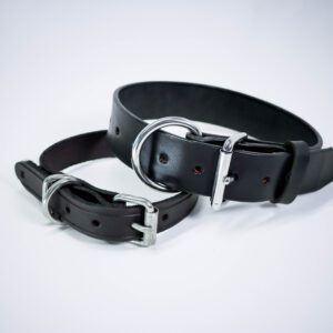 A pair of black leather collars with silver buckles.