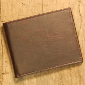 A brown wallet sitting on top of a wooden table.