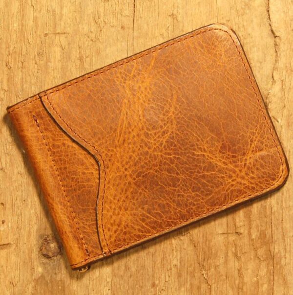 A brown wallet sitting on top of a wooden table.