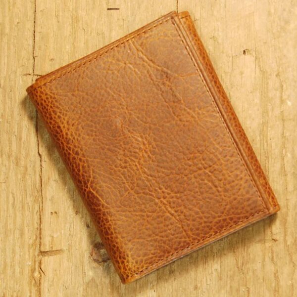 A brown wallet sitting on top of a wooden table.