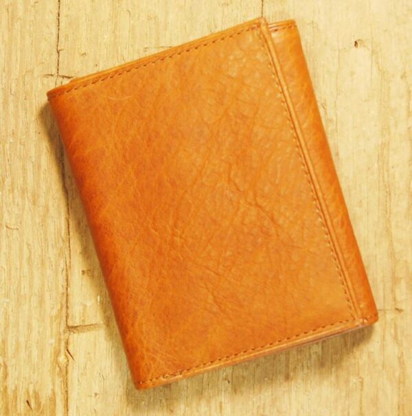 A brown wallet sitting on top of a wooden table.